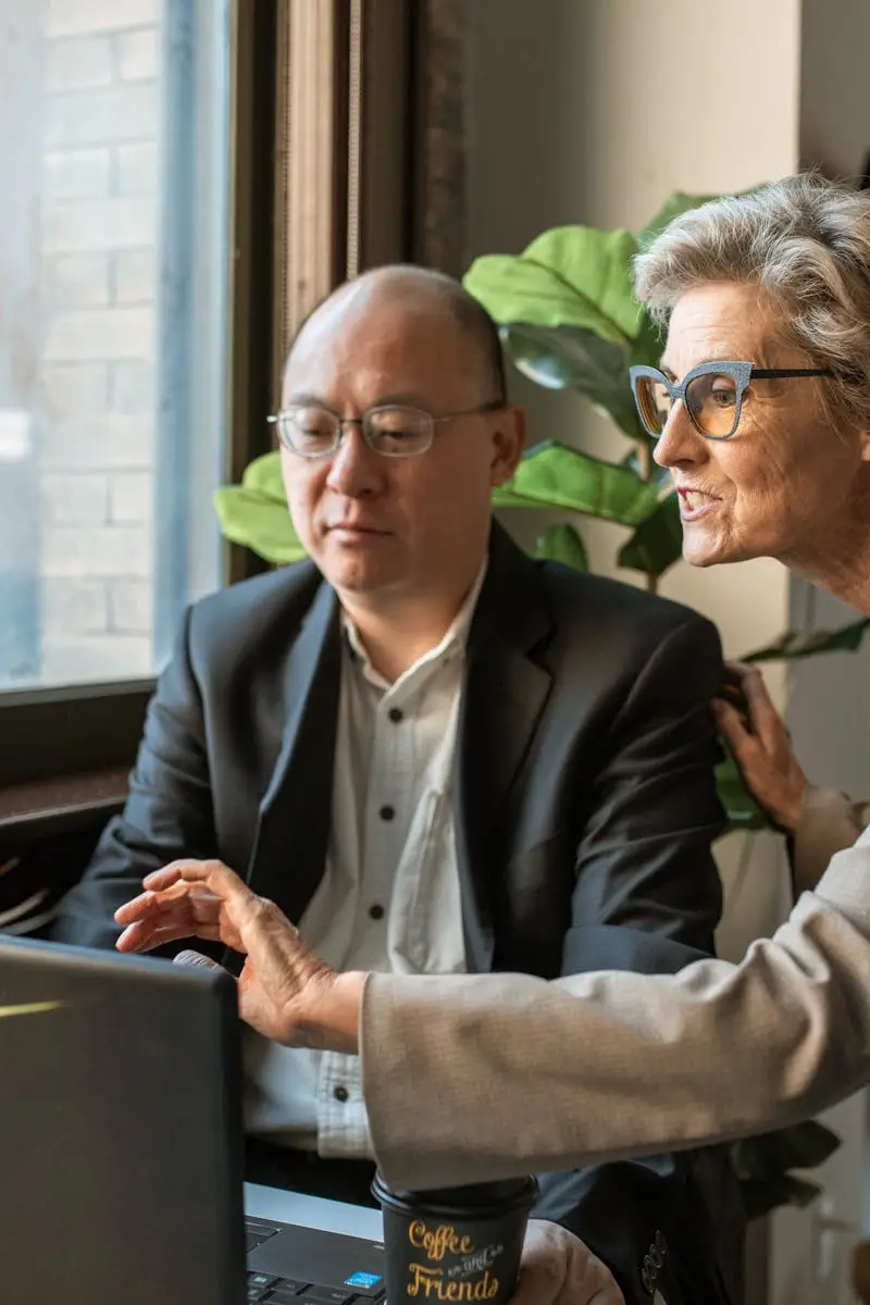 Senior professionals discussing a project at a modern office workspace.