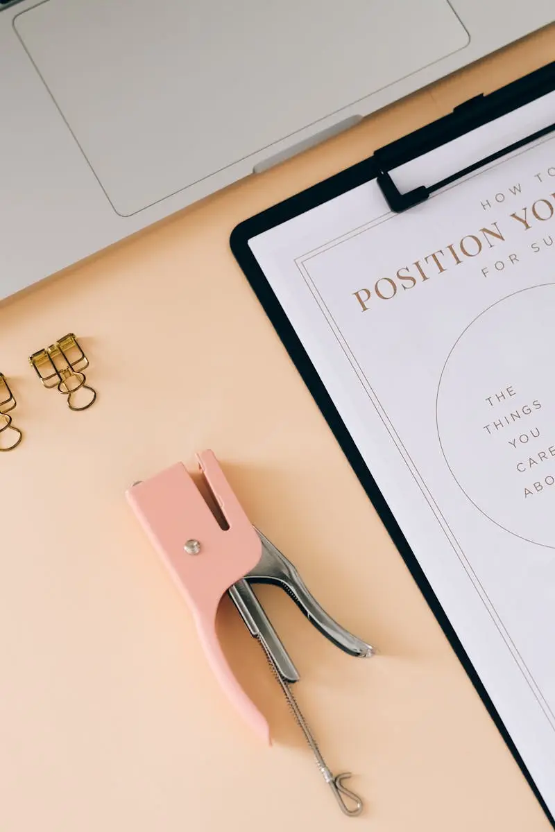 A flat lay composition featuring office essentials and a branding strategy clipboard on a modern workspace.